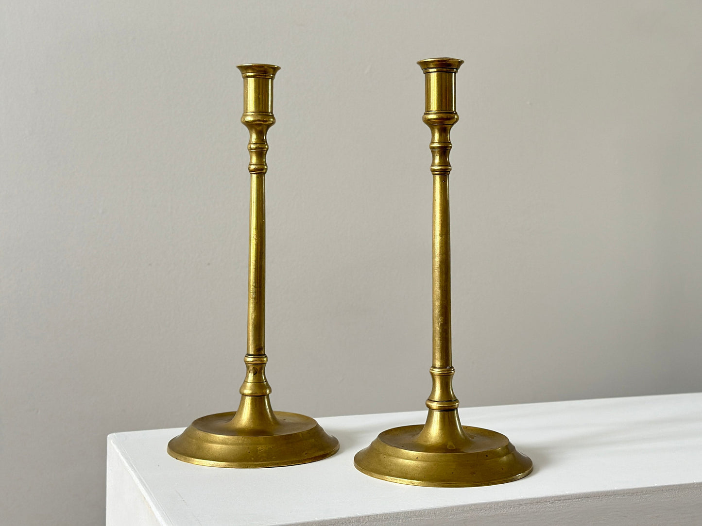 19th Century – Pair of tall solid brass candlesticks, made in England