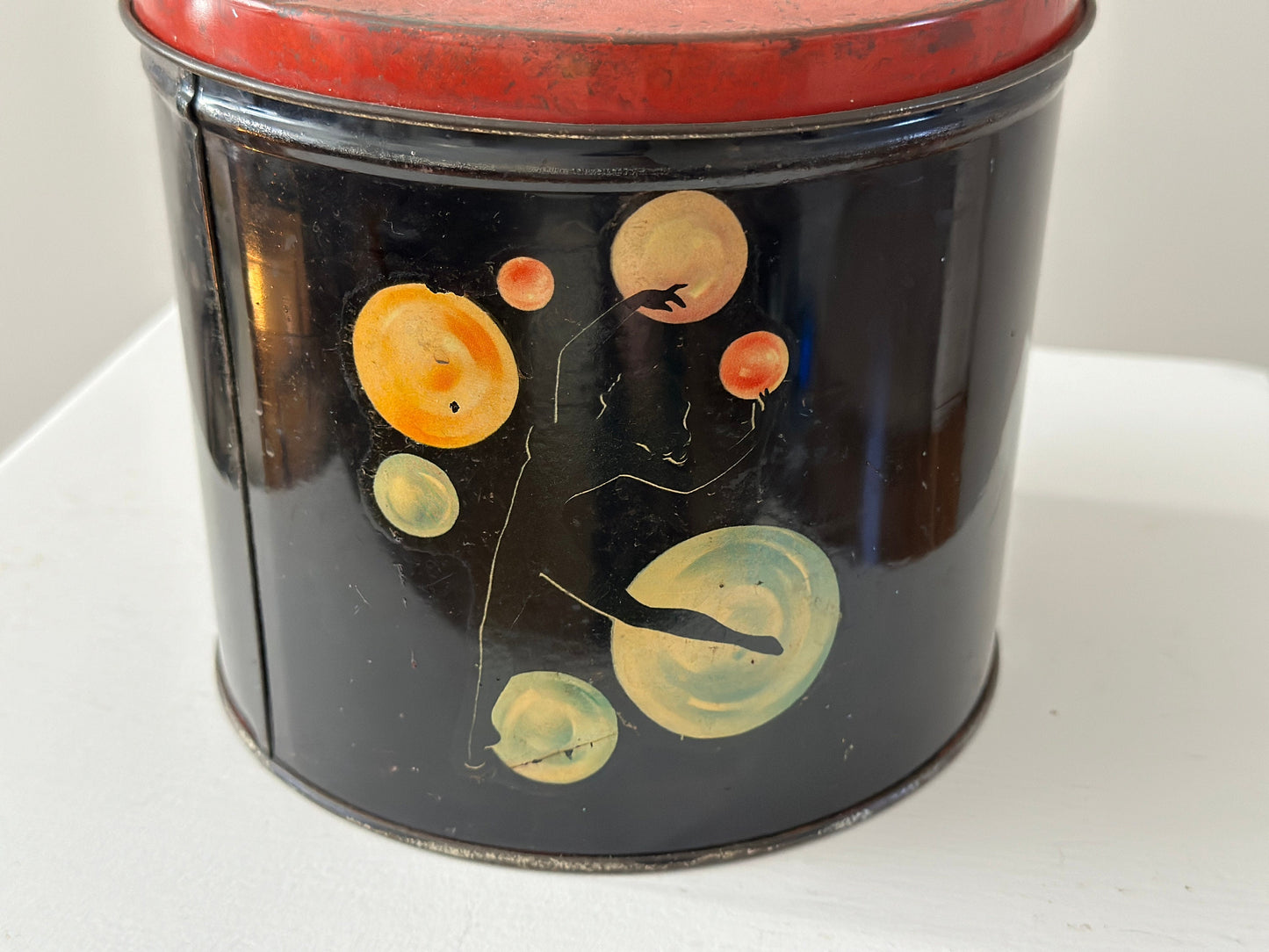 1940s – Tin canister with pinup dancer graphics