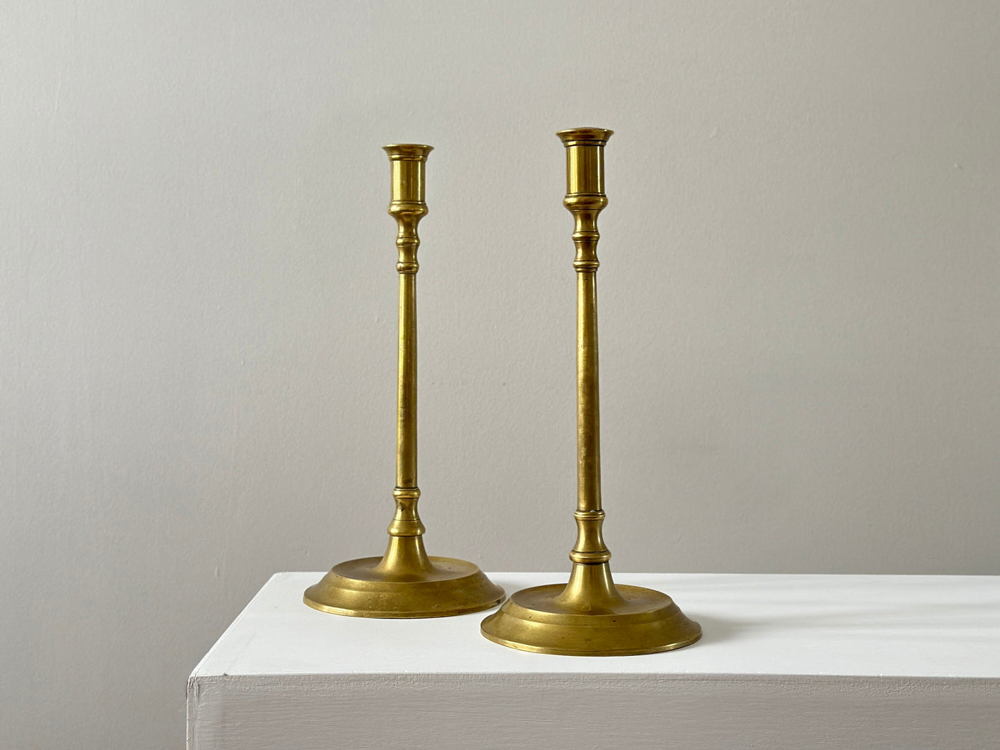 19th Century – Pair of tall solid brass candlesticks, made in England