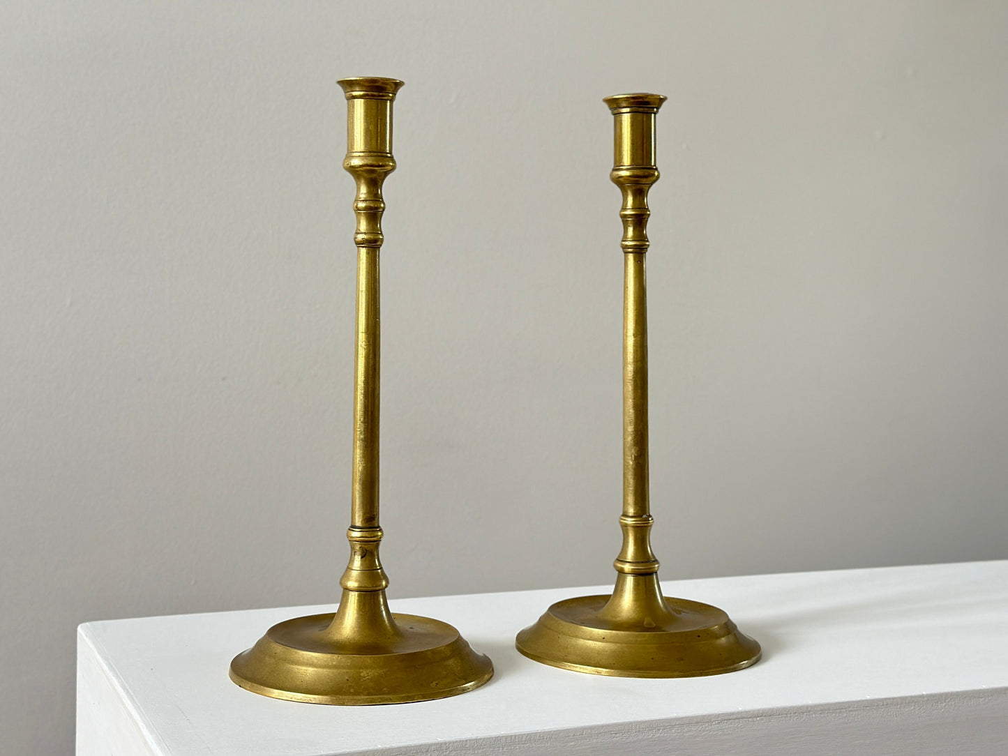 19th Century – Pair of tall solid brass candlesticks, made in England