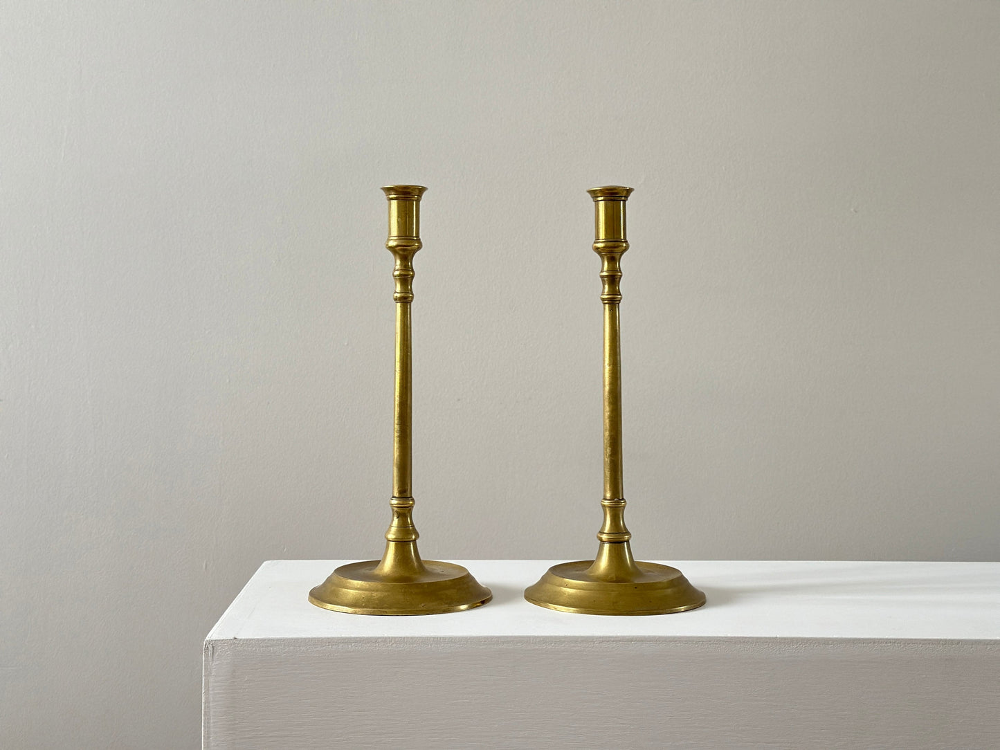 19th Century – Pair of tall solid brass candlesticks, made in England