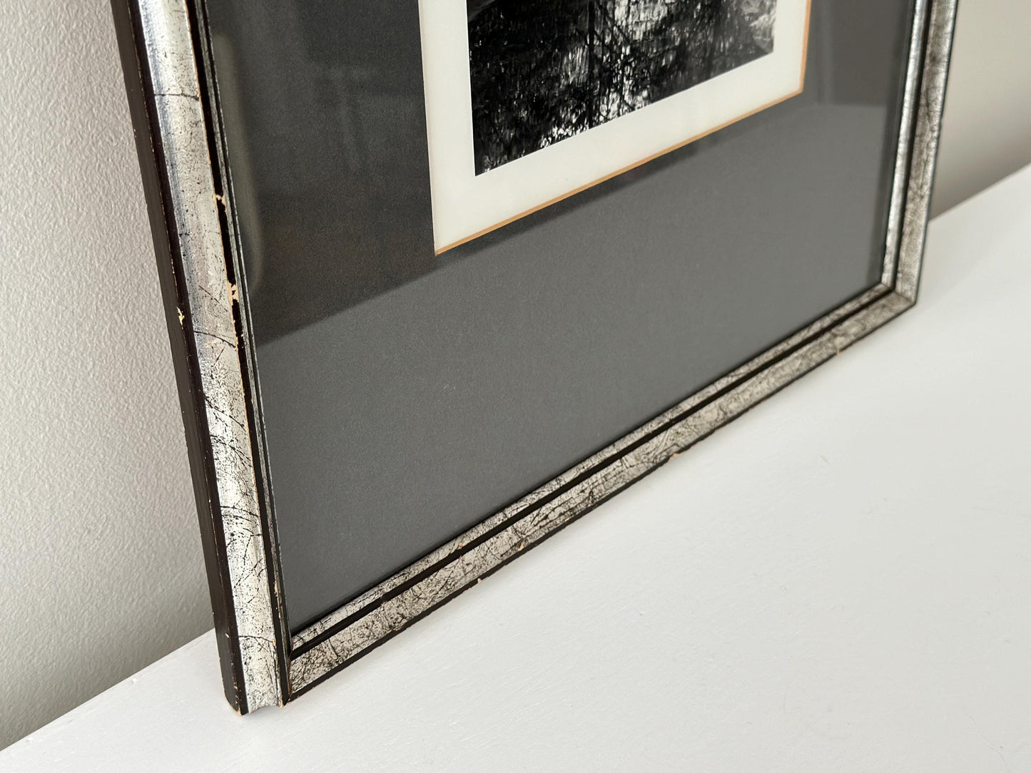 Vintage black and white photograph of a woman crouching in a brook in a vintage frame